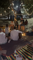 Evening beach gathering under string lights in Pattaya