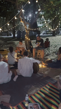 Evening beach gathering under string lights in Pattaya