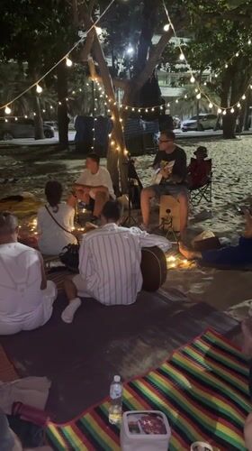 Evening beach gathering under string lights in Pattaya
