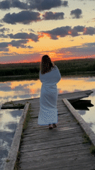 Sunset at a quiet Russian lake, dock and wildflowers in view