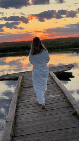 Sunset at a quiet Russian lake, dock and wildflowers in view