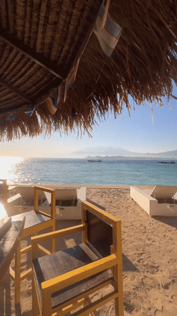 Empty lounge chairs and turquoise water on a Lombok beach