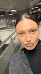 Woman films selfie content at London Underground station
