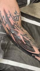 Person shows off fresh abstract forearm tattoo with bold geometric design