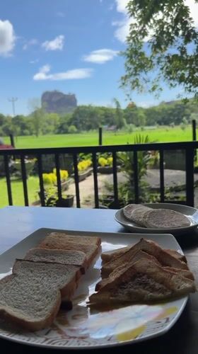 Tourist captures dawn view of Sigiriya Rock from balcony