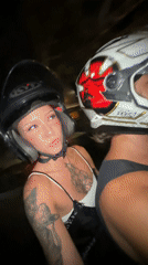Two helmeted riders travel by motorbike in Kuta Utara