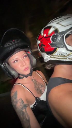 Two helmeted riders travel by motorbike in Kuta Utara