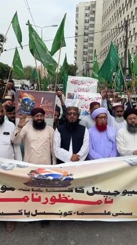 Religious procession marches through Karachi with flags and protest banners