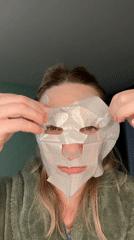 Woman applies dotted facial mask in green robe