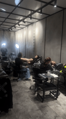 Tattoo artists work on multiple clients in Moscow parlor
