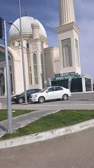White mosque observed on busy street corner in Syrdarya