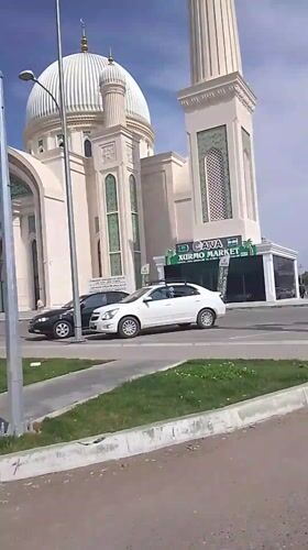 White mosque observed on busy street corner in Syrdarya