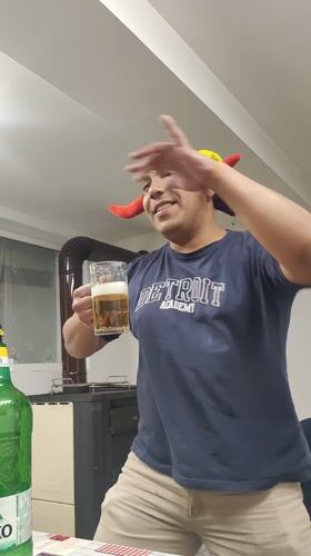 Person in jester hat celebrates with beer in Damianovo