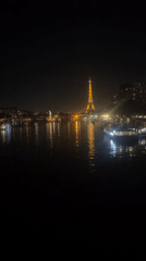 Eiffel Tower glowing gold over the Seine at night
