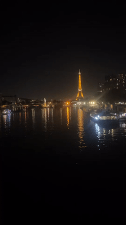 Eiffel Tower glowing gold over the Seine at night