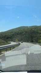 Car travels curved highway near Zmeyovo under clear skies