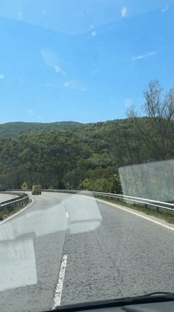 Car travels curved highway near Zmeyovo under clear skies