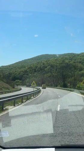 Car travels curved highway near Zmeyovo under clear skies