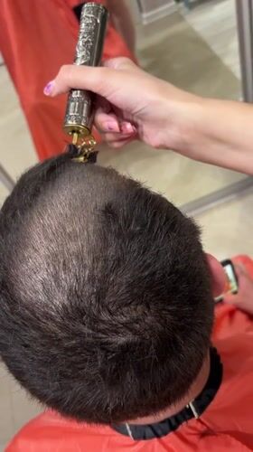 Person Gets Haircut with Decorative Trimmer in Irkutsk