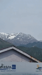 Morning street life captured in Dharamshala against snowy mountains