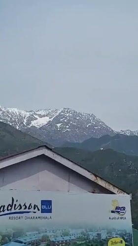Morning street life captured in Dharamshala against snowy mountains