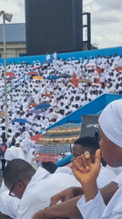 White-clad crowd gathers at outdoor stadium in Calabar