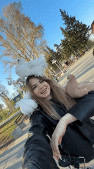 Woman films selfie video with pigeons near park monument