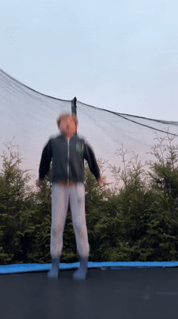 Child plays on trampoline during sunset in Carnikava, Latvia