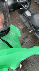 Motorcyclist in rain gear spotted near bikes in Mengwi