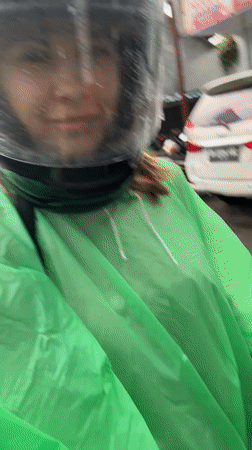 Motorcyclist in rain gear spotted near bikes in Mengwi