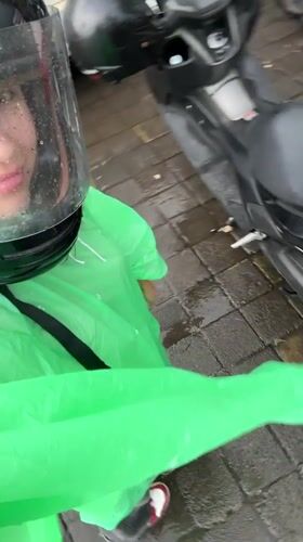 Motorcyclist in rain gear spotted near bikes in Mengwi