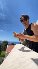Man enjoys fruit breakfast on seaside balcony in Montenegro