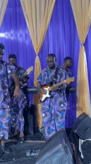 Band performs in matching purple outfits on decorated stage