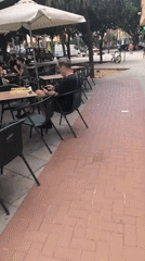 Valencia sidewalk scene: cafés, a parked motorcycle, and street details