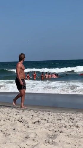 NYPD helicopter circles as beachgoers gather in the surf