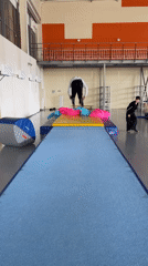 Athletes practice backflips in Krasnoyarsk gymnasium during early morning session