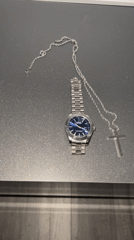 Watch and cross chain laid out for a #WristCheck post