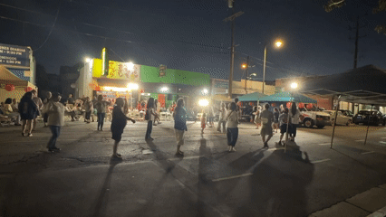 Late-night street gathering with live drumming in Los Angeles