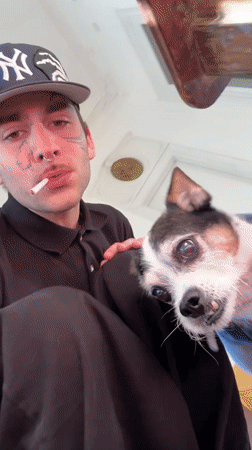 Tattooed man with dog observed smoking on Buenos Aires balcony