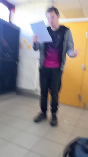 Student reads from papers in Schiltigheim school hallway