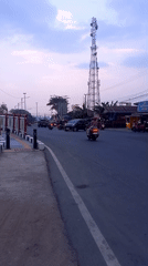 Roadside markets, a mosque, and street traffic in Melayu, Indonesia