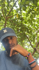 Man in blue cap photographed smoking under trees in Jos