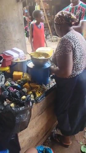 Woman and baby rest under shelter in Onitsha market