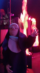 Person in nun costume gestures at camera near Cannes stage