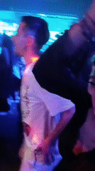 Nightclub scene captured with dancing patrons and bartender service