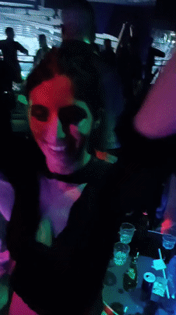 Nightclub scene captured with dancing patrons and bartender service