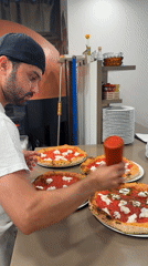 Pizza prep in a Trento kitchen, sauce being drizzled