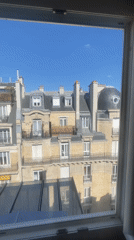 Parisian rooftop views from inside a building on a clear afternoon