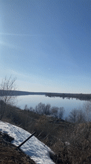 Spring scene captured along calm river in Noviy, Russia