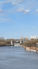 Train crosses Moscow river bridge on spring morning
